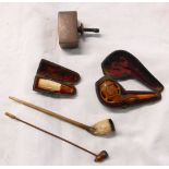 A small collection of antique pipes, comprising a cased meerschaum claw with amber mouthpiece,