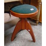 A retro stained wood adjustable piano stool with upholstered top, screw action and tripod base