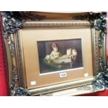 A gilt framed and slipped oil on panel depicting three children looking at puppies in a manger in