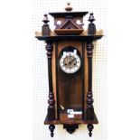 An early 20th Century walnut cased Vienna style wall clock with ornate pediment, flanking half