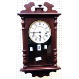 A modern stained wood cased wall clock with visible pendulum and chiming movement