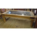 A 3' 10" eastern hardwood coffee table, iron bound and with iron chain-link grills under glass top