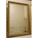 A modern gilt framed bevelled oblong wall mirror with decorative and beaded border