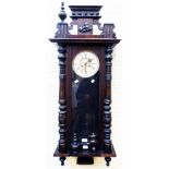 A large early 20th Century stained wood cased Vienna style wall clock with ornate pediment, flanking