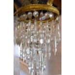 A gilt metal pendant ceiling light with three graduated tiers of faceted glass lustres