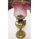 A Duplex brass table oil lamp with acid etched cranberry glass shade