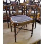 An Edwardian inlaid mixed wood framed corner elbow chair with decorative splats and upholstered seat
