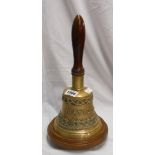 A large bell with embossed decoration, named Taylor and dated 1901, on circular wood stand