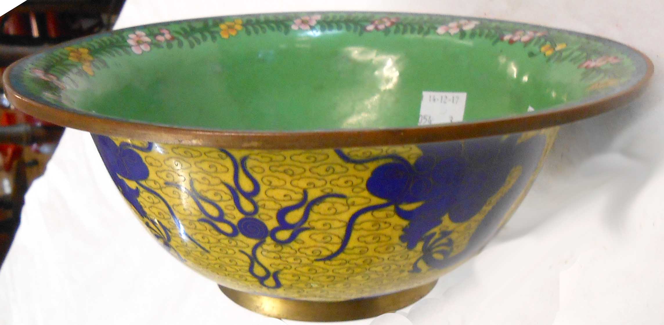 An 8 3/4" diameter cloisonné lipped bowl with floral border on green ground within a yellow exterior