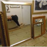 A modern gilt framed wall mirror - sold with a pine framed similar and another