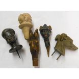 A collection of five various small carved head pattern stoppers and finials