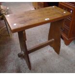 A 24" oak plank topped side table with stained pine standard ends and pegged stretcher