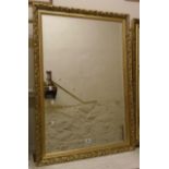 A modern gilt framed bevelled oblong wall mirror with decorative and beaded border