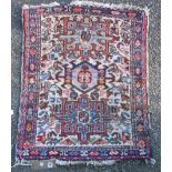 A Persian wool mat with geometric medallions and floral ground within reciprocating filler