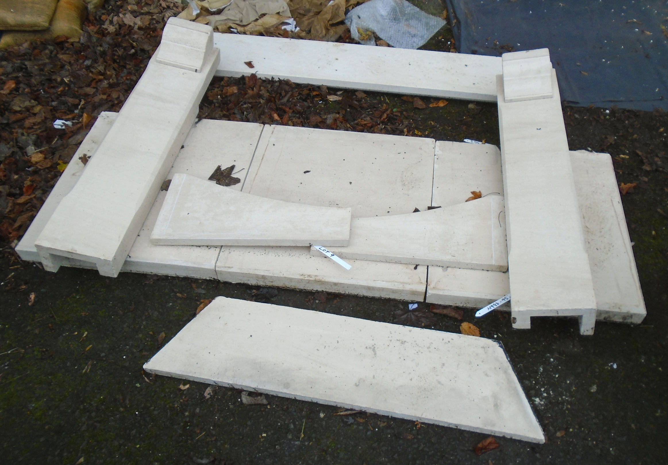 A polished limestone effect fire surround with flanking bracket capitals and sectional hearth