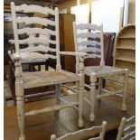 A set of four painted wood framed ladder back dining chairs with woven rush seats and turned front