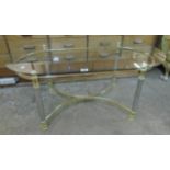 A 3' 7 1/2" modern glass topped coffee table, set on an oval base with brassed and chromed