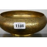 A 10" diameter Middle Eastern heavy brass footed bowl with incised foliate and floral decoration