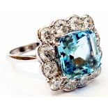 A marked 18ct. white metal ring, set with central 4.24ct. aquamarine within a twelve stone diamond