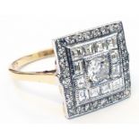 A marked 18ct. yellow metal ring with paved and brilliant cut diamonds to square panel - 1ct. TDW