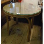 A 23 1/2" diameter Lloyd Loom style tea table with glass top, original old gold sprayed finish and