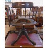 An early 20th Century stained oak framed office swivel tub chair with spindle decoration and branded