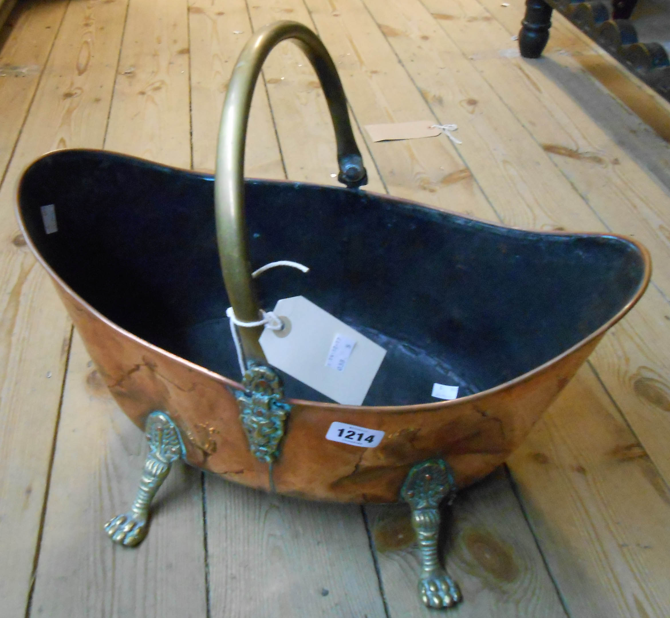 An elliptical swing handled copper coal bucket with lion mask bosses and claw feet