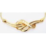 A marked .750/18k yellow metal pendant necklace with paved baguette diamonds to central bow