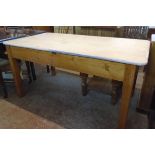 A 4' 11 1/2" pine scrub top kitchen table with opposing porcelain handled drawers, set on simple