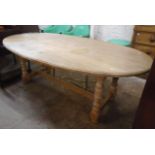 A 7' kitchen table with oval maple top, set on a pine farmhouse base with flanking twin turned