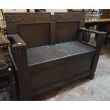 A 3' 4" 20th Century stained oak hall bench with moulded panelled back, flanking stick stands and