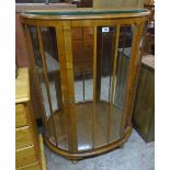 A 35" mid 20th Century walnut veneered bow front display cabinet with two glass shelves and mirrored