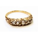 An antique high carat yellow metal five stone diamond ring with engraved shoulders - marks