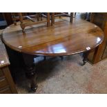 A 4' 2" 19th Century mahogany circular drop-leaf table, set on turned legs with brass caps and