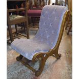 A 19th Century walnut framed nursing chair with violet button back upholstery, set on scroll