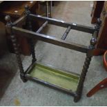 A 20th Century stained oak umbrella stand with bobbin turned supports and metal drip tray