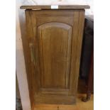 A stained wood pot cupboard with arched panel door
