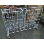 An industrial galvanised tubular metal and wire framed bottle rack, set on rubber casters