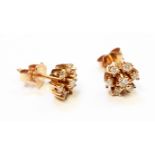 A pair of marked 750 yellow metal stud ear-rings, each with seven small diamonds in flowerhead