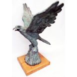 A 28 1/2" high patinated hollow cast bronze model of an eagle with wings spread, set on an oak
