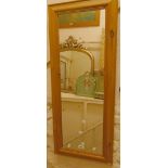 A modern waxed pine framed wall mirror with narrow oblong plate