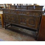 A 5' early 20th Century stained oak sideboard in the Jacobean style with a low raised back, two