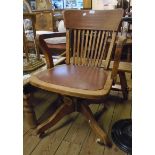 An early 20th Century stained wood framed lath back office swivel chair with metal tilt/rise and