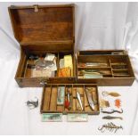 A stained wood concertina chest with tray fitted interior containing a collection of sea fishing