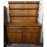 A 4' 1" Ercol elm two part dresser with two shelf open plate rack, over a base with tray fitted