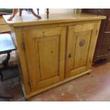 A 4' 1 1/4" Victorian waxed pine larder cupboard with shelves enclosed by a pair of panelled