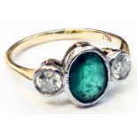 A marked 18ct. yellow metal ring, set with central oval emerald flanked by two diamonds