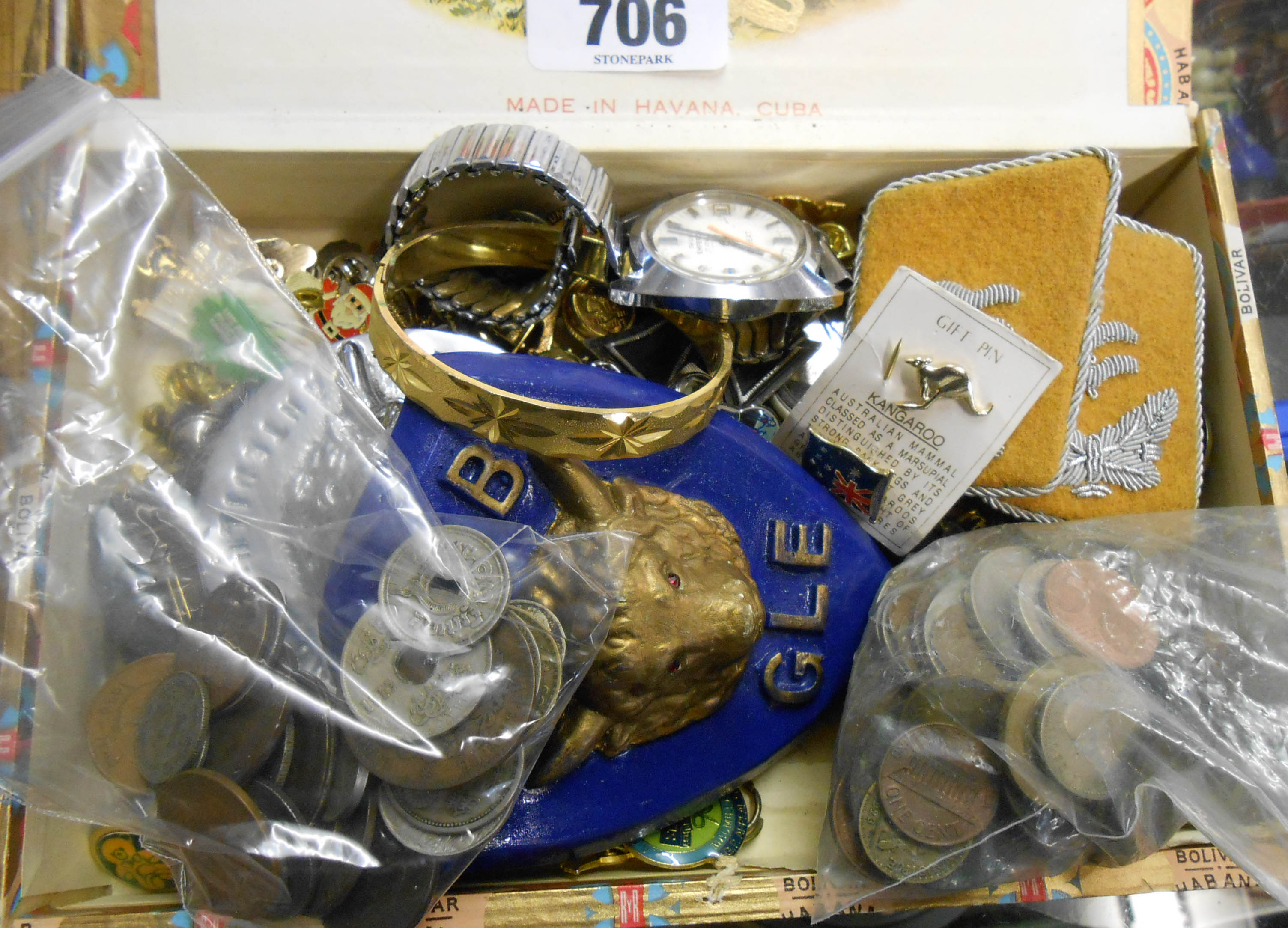 A cigar box containing various collectables including R.A.O.B. car badge, lapel badges and other