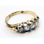 An 18ct. gold five stone diamond ring with engraved shoulders