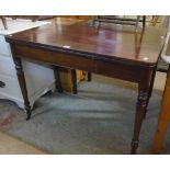 A 3' 5" 19th Century mahogany fold-over tea table, set on ring turned legs with brass caps and